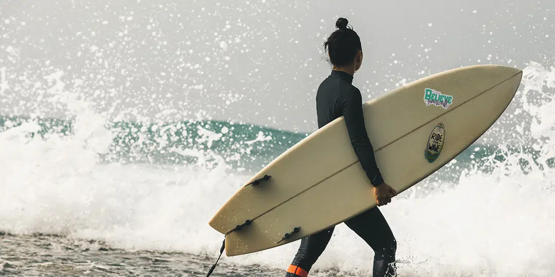 mujer con tabla de surf con sticker personalizado